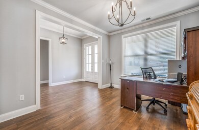 Home office featuring crown molding, dark hardwood