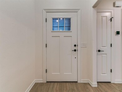 Doorway to outside with wood finished floors and baseboards