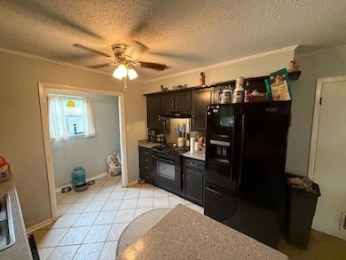 Kitchen with black appliances, crown molding, a c