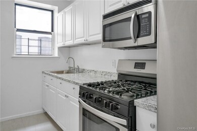 Kitchen featuring sink, appliances with stainless steel finishes, and white cabinetry