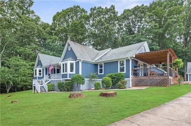 View of front facade with stairway, a front lawn, a shingled roof, a ceiling fan, and board and batten siding
