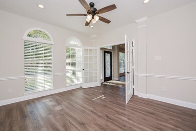 The home office has double French doors and custom blinds, recessed lighting and a new fan