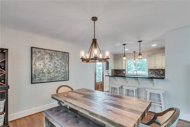 Dining area leading into kitchen with breakfast ba