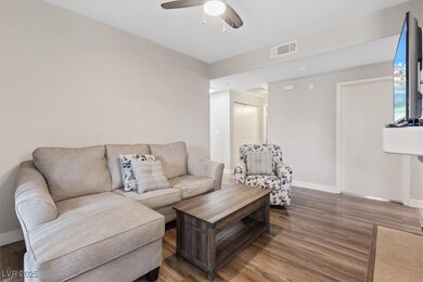 Living area with visible vents, ceiling fan, baseb