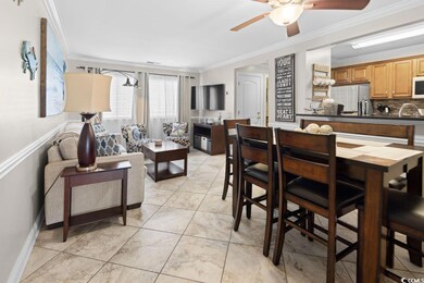 Tiled dining space featuring ceiling fan and crown