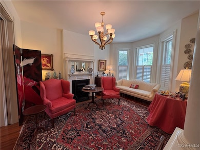 Living room with chandelier and fireplace with ori