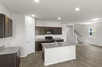 Kitchen featuring black microwave, range with gas