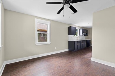 Unfurnished living room with baseboards, dark wood-style floors, and ceiling fan