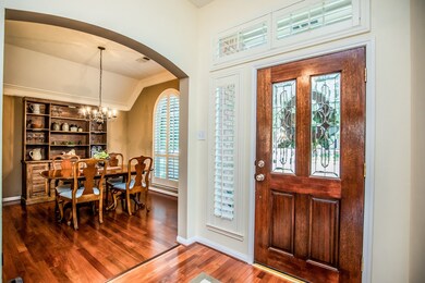 Arch doorways, 10' ceilings, thick moldings, and a handsome leaded glass door welcome guests.