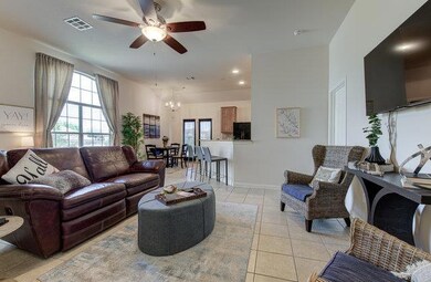 Living area featuring a ceiling fan, light tile p