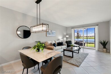 Dining area with a water view, light tile patterned floors, and a chandelier