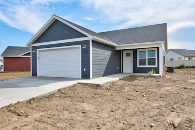 Ranch-style house featuring driveway, an attached garage, and a shingled roof