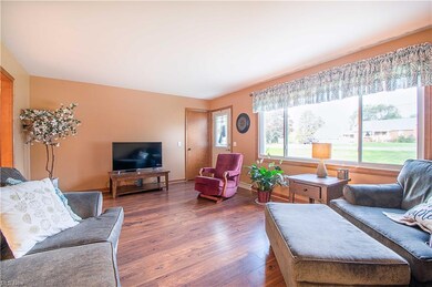 Inside, the bright and airy living room welcomes you with a large picture window and beautiful laminate floors.