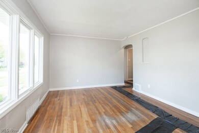 Empty room featuring crown molding and hardwood / wood-style floors