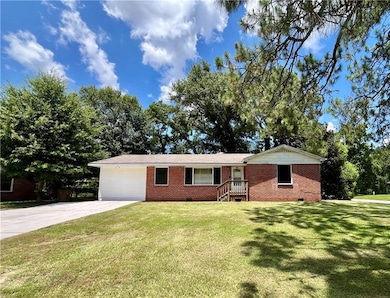 Ranch-style home with crawl space, driveway, brick siding, and a front lawn