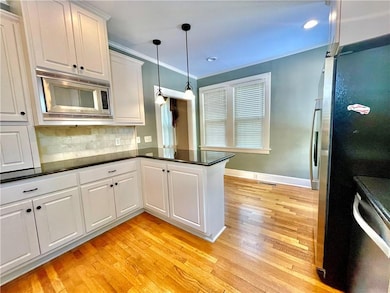 Kitchen featuring a peninsula, dark countertops, a