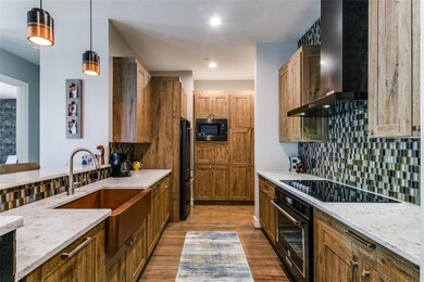 Kitchen featuring black appliances, wall chimney e