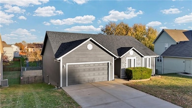 View of front facade featuring driveway, a garage, roof with shingles, and stone siding