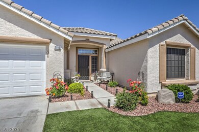Front showing beautiful flowers, shrubs & faux gra