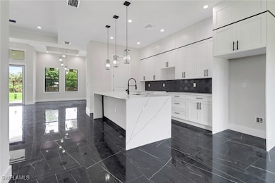 Kitchen featuring dark marble finish floors, backs