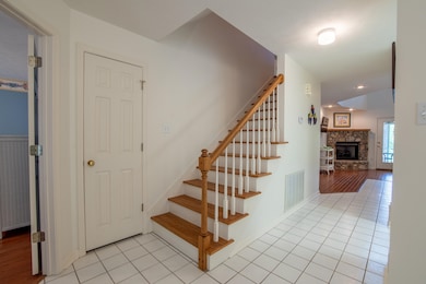 Stairway with a stone fireplace and wood-type floo