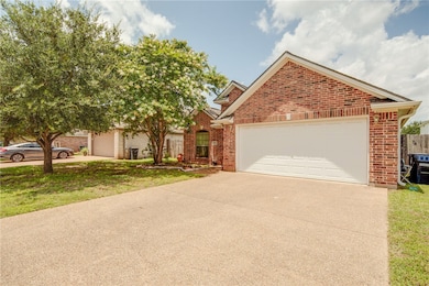 View of front facade with brick siding, driveway,