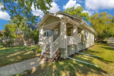 View of home's exterior with a lawn, a porch, and stairway