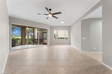 Empty room with ceiling fan, ornamental molding, and light tile patterned floors