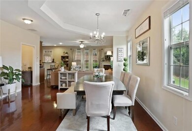 Dining area with a chandelier, wood finished floors, and a ceiling fan