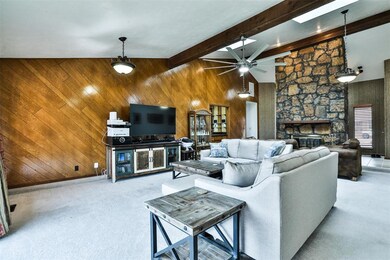 Carpeted living room featuring a fireplace, beamed