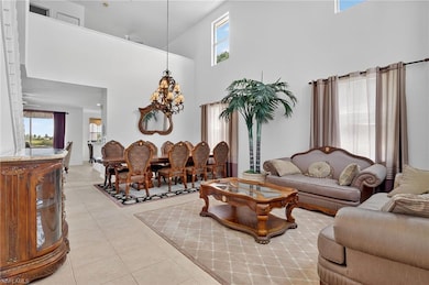 Living room featuring a towering ceiling, light tile patterned floors, and a chandelier