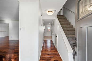 Hall with dark wood-type flooring and stairs