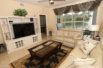 Living room featuring ceiling fan, a water view, a