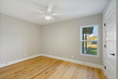 Empty room with baseboards, a ceiling fan, and li