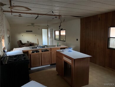 Kitchen featuring gas stove, ceiling fan, sink, a