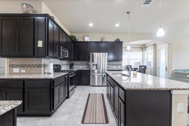 Kitchen featuring visible vents, light stone coun