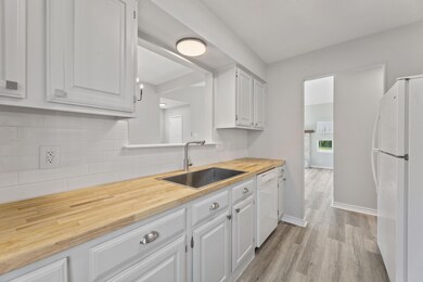 Kitchen with tasteful backsplash, a sink, white a
