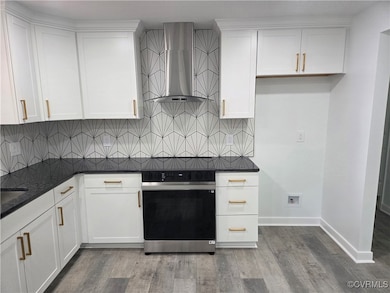 Kitchen with wall chimney exhaust hood, oven, tast