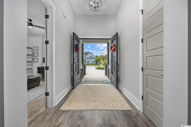 Entryway with wood finished floors, a chandelier, and a ceiling fan