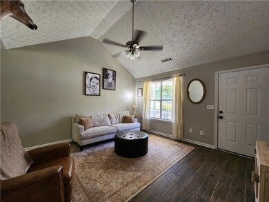 Living room featuring a ceiling fan, vaulted ceili