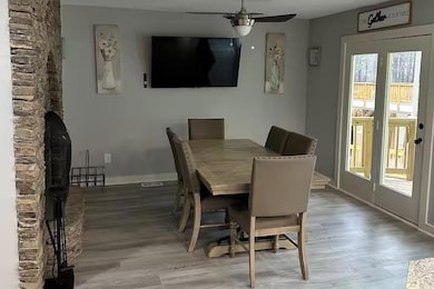 Dining area with wood flooring, abundant natural light, and access to outdoor views.