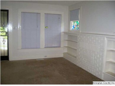 Living room provides built in shelving for storage