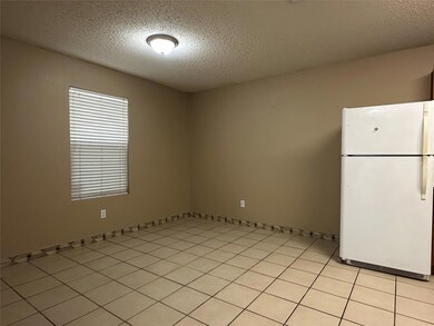 Empty room featuring light tile patterned floors and a textured ceiling