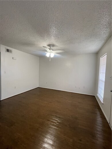 Empty room featuring dark wood-style floors, ceili