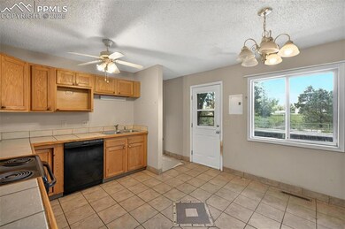 Kitchen featuring dishwasher, tile counters, a sink, electric range oven, and a chandelier