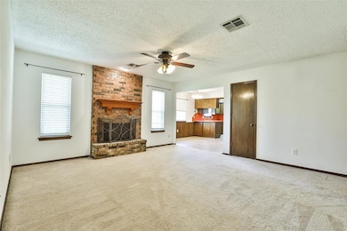 Unfurnished living room featuring ceiling fan, a fireplace, carpet flooring, a textured ceiling, and baseboards