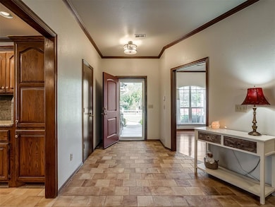 Foyer featuring crown molding and a textured wall