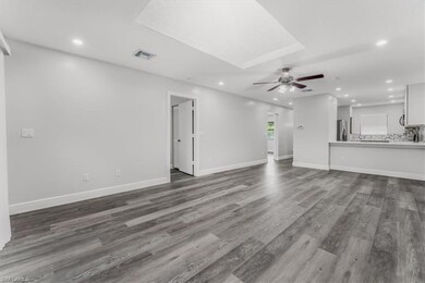 Unfurnished living room with ceiling fan, recessed lighting, and dark wood-style floors