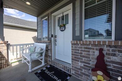 Property entrance with a porch and brick siding