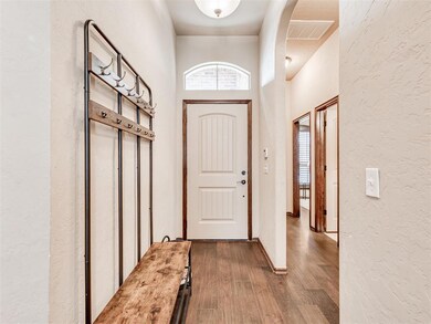 Entryway featuring a towering ceiling and dark har